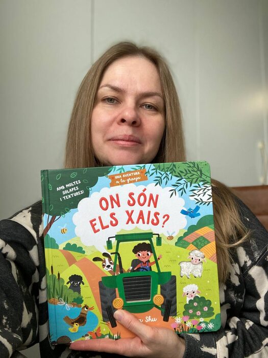 Masha Shu holding a published edition of her illustrated book