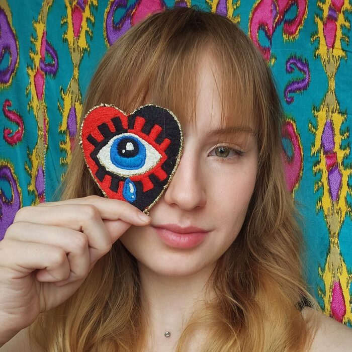 Sasha Papercut holding a colourful paper artwork